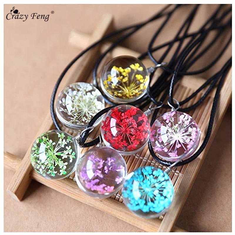 Dried flower in glass ball pendant on a women's black leather rope chain choker necklace.